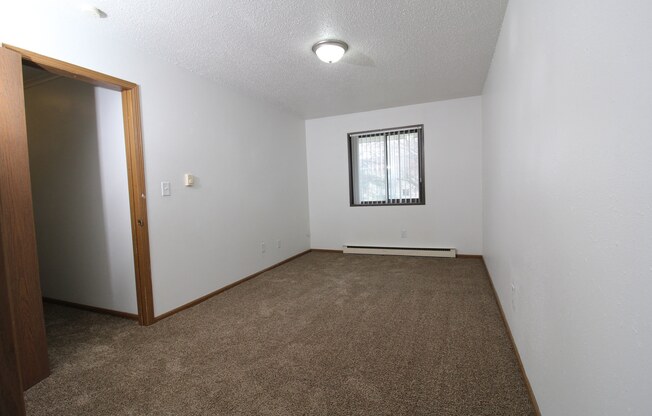 a small empty room with a window and a door