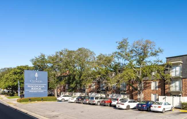 A parking lot in front of a building with a sign that says "Cypress Magnolia".