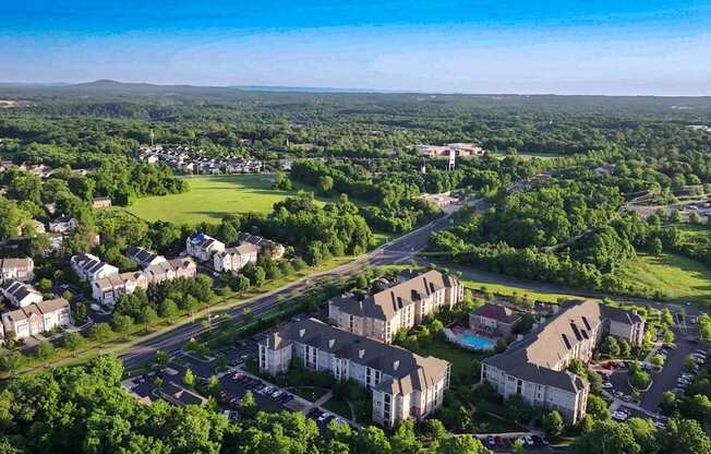 A bird's eye view of a residential area with houses and a swimming pool.