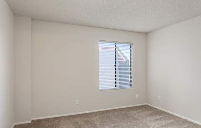 A room with a window covered by blinds.
