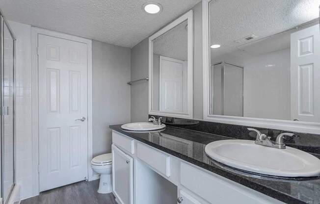 A bathroom with a sink, toilet, and mirror.