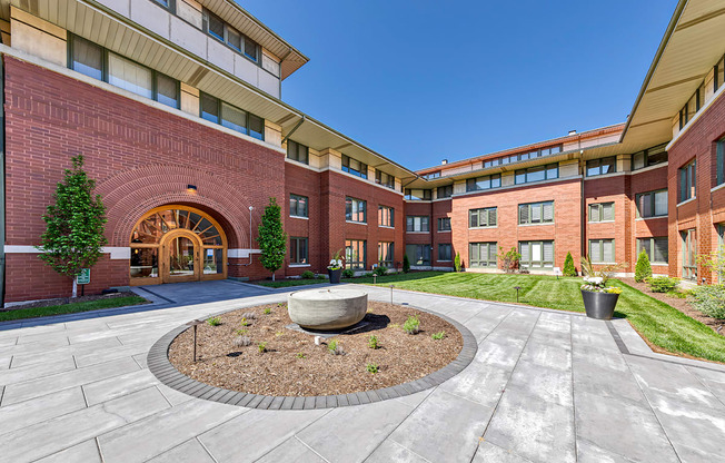 A courtyard with a circular planter in the middle of a paved area.