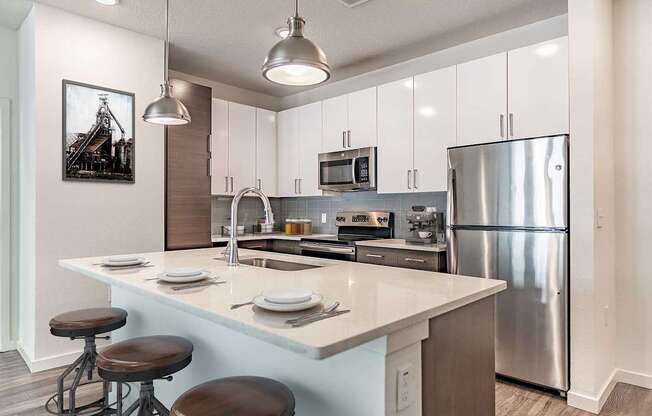 A modern kitchen with a large island and stainless steel appliances.