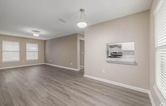 A room with a wooden floor and a window with blinds.