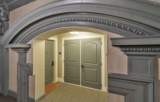 an empty hallway with an archway and two doors at The Knights @ 506 Delaware Apartments, Buffalo, NY 14202