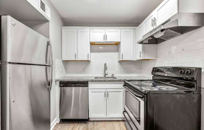 a kitchen with stainless steel appliances and white cabinets