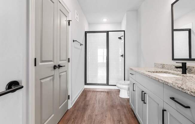 A bathroom with a toilet, sink, and mirror.