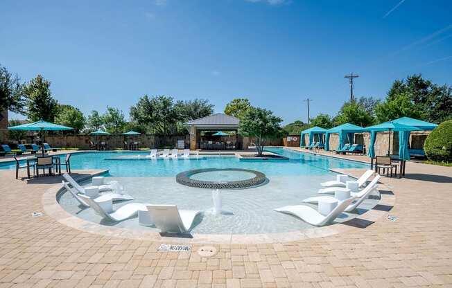 a resort style swimming pool with lounge chairs and umbrellas