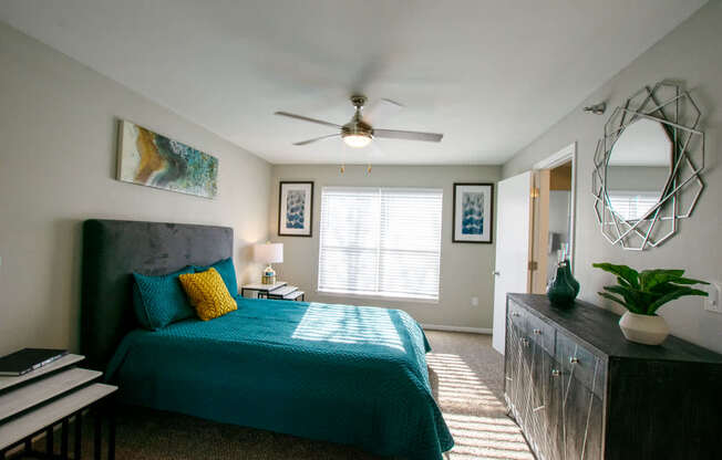A bedroom with a bed, a dresser, and a mirror.