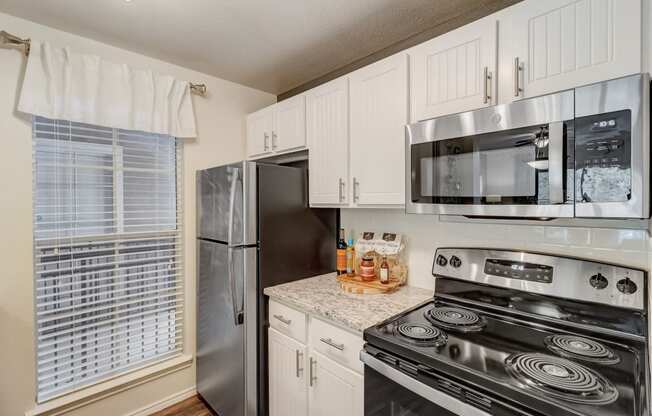 an updated kitchen with stainless steel appliances and white cabinets