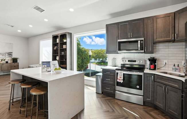 A modern kitchen with a white island and stainless steel appliances.