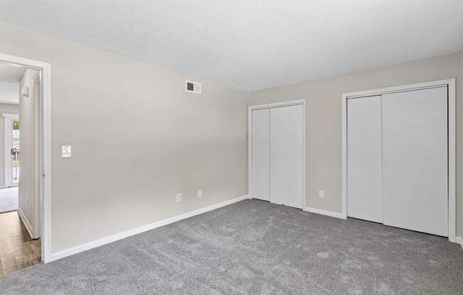 A room with a grey carpet and white walls.