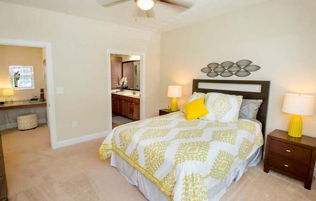 A bedroom with a bed, nightstand, and a ceiling fan.