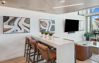 a living room with a white table and chairs and a tv on the wall