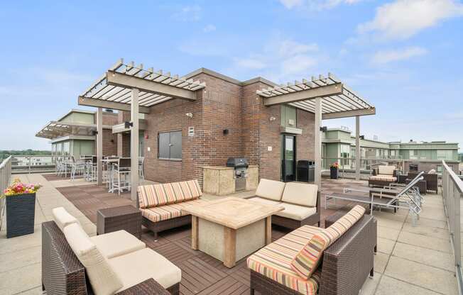 a patio with couches tables and chairs and a brick building