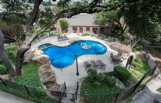 an aerial view of a backyard with a pool and patio