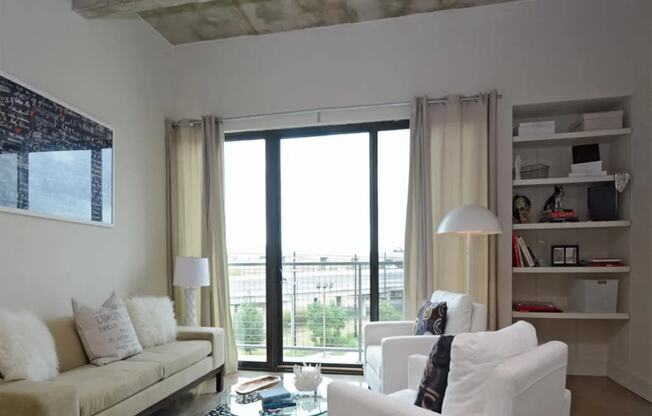 a living room with white furniture and a balcony