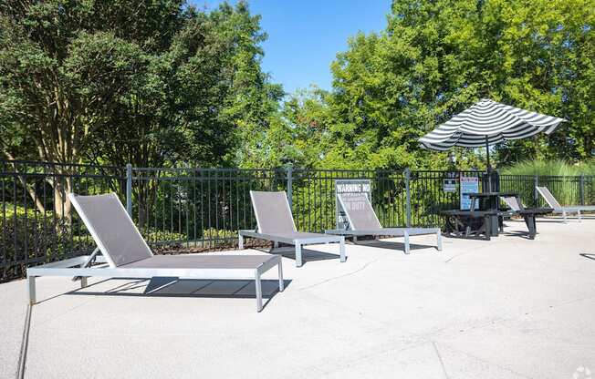 the patio has two lounge chairs and an umbrella