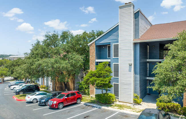 A parking lot with cars and a building in the background.