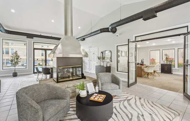 a living room with a fireplace and chairs and a rug