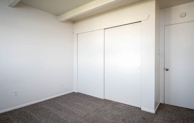 A room with a carpeted floor and white walls.