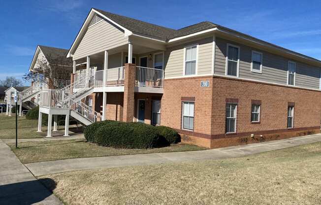 the front of a brick house with a porch and stairs