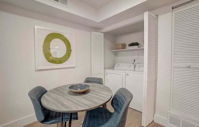 A dining room with a round table and chairs.