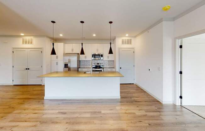A kitchen with a wooden floor and white walls.
