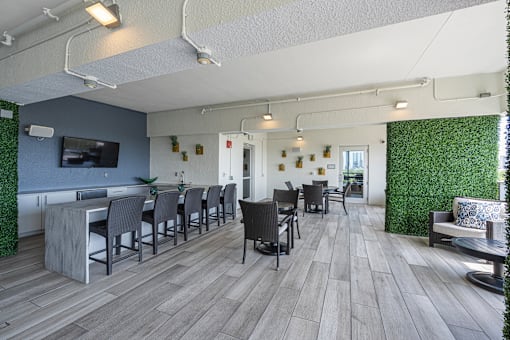 a communal area with chairs and tables and a television in a lobby