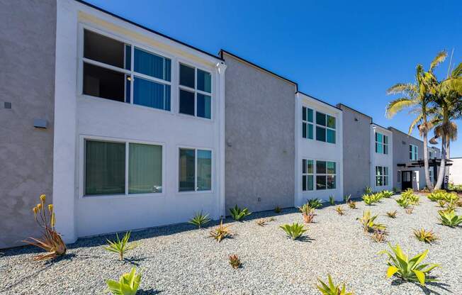 A white building with a gravel area in front of it.