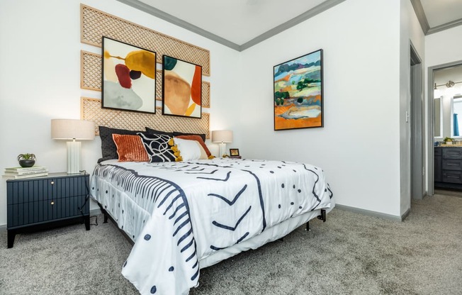 a bedroom with a bed and paintings on the wall