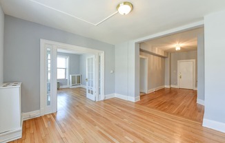 vacant living area with hardwood floors, french doors and view of foyerat the shawmut apartments in washington dc