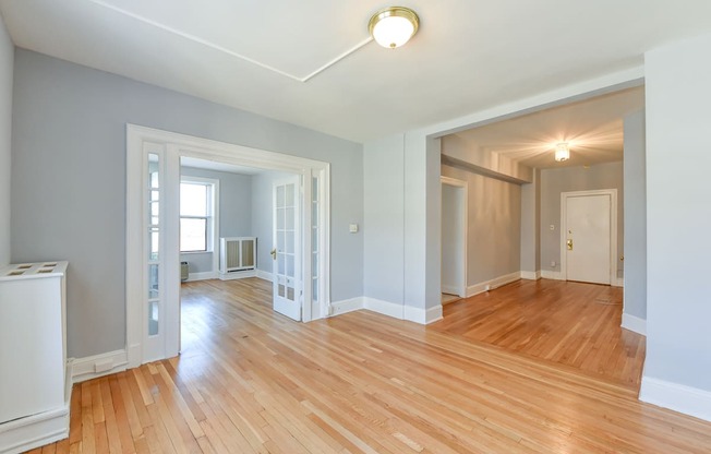 vacant living area with hardwood floors, french doors and view of foyerat the shawmut apartments in washington dc