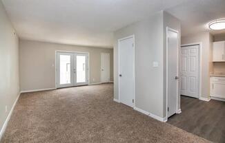 an empty living room and kitchen with white doors at Cleo Apartments, Athens
