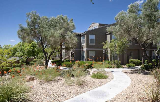 Walking path to a building surrounded by vegetation and trees.