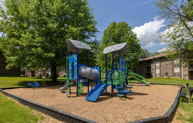 A playground with a blue slide and a green slide.