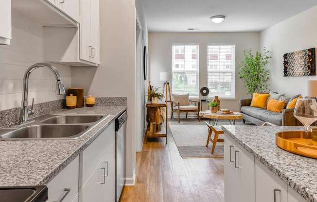 A modern kitchen with a dining area in the background.