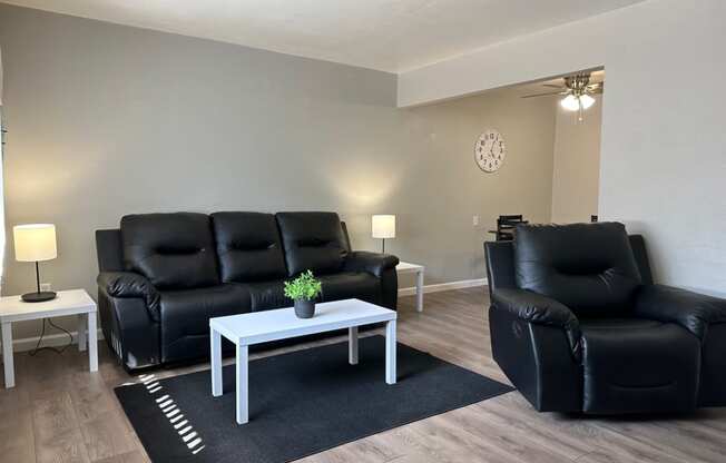 a living room with black leather furniture and a white coffee table