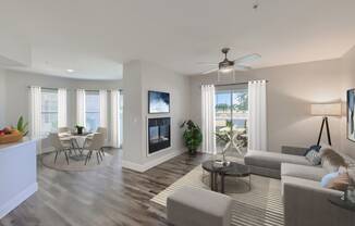 a living room with a fireplace and a dining room in the background