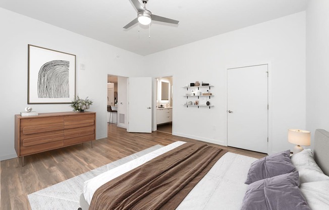 A bedroom with a bed, dresser, and a painting on the wall.