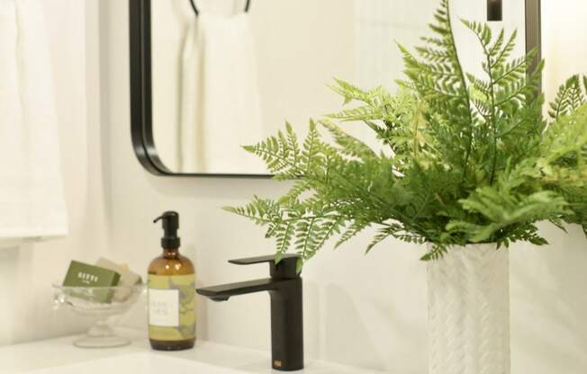 a bathroom sink with a vase of flowers on it