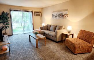 a living room with a couch and a chair and a window