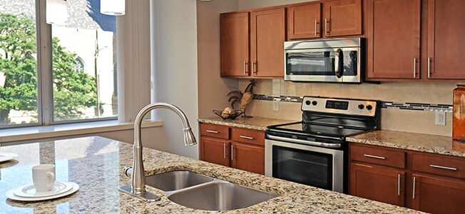 a kitchen with granite counter tops and stainless steel appliances