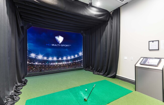 A golf simulator room with a screen showing a stadium and the words "HD Multi-Sport".
