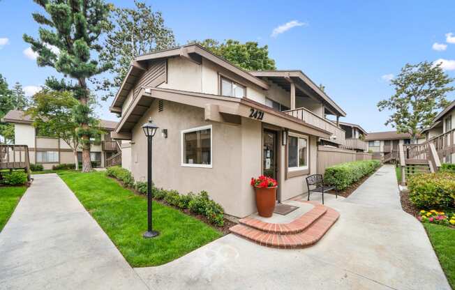 a house with a concrete walkway and a bench in front of it