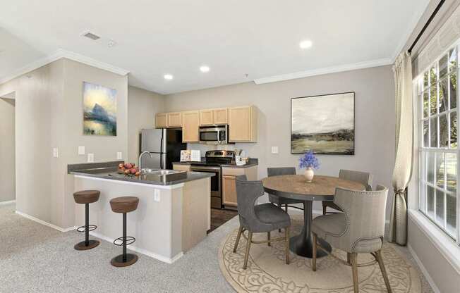 a living room with a kitchen and a dining area with a table and chairs