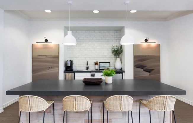 a kitchen with a black counter top and a table with chairs