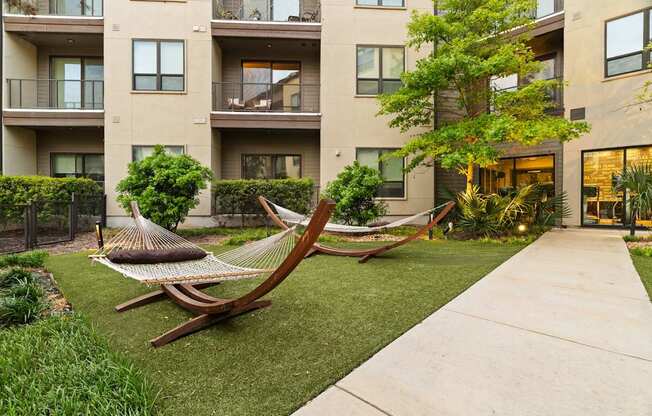 A hammock is placed in the front yard of a building.