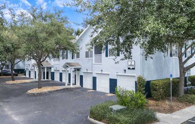 A white building with a parking lot in front.