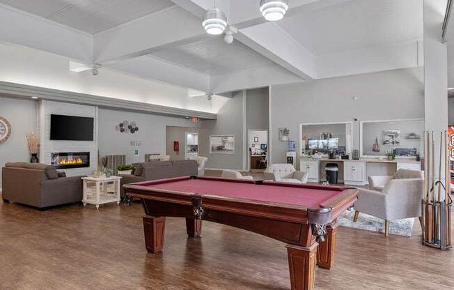 a pool table in a room with couches and a fireplace